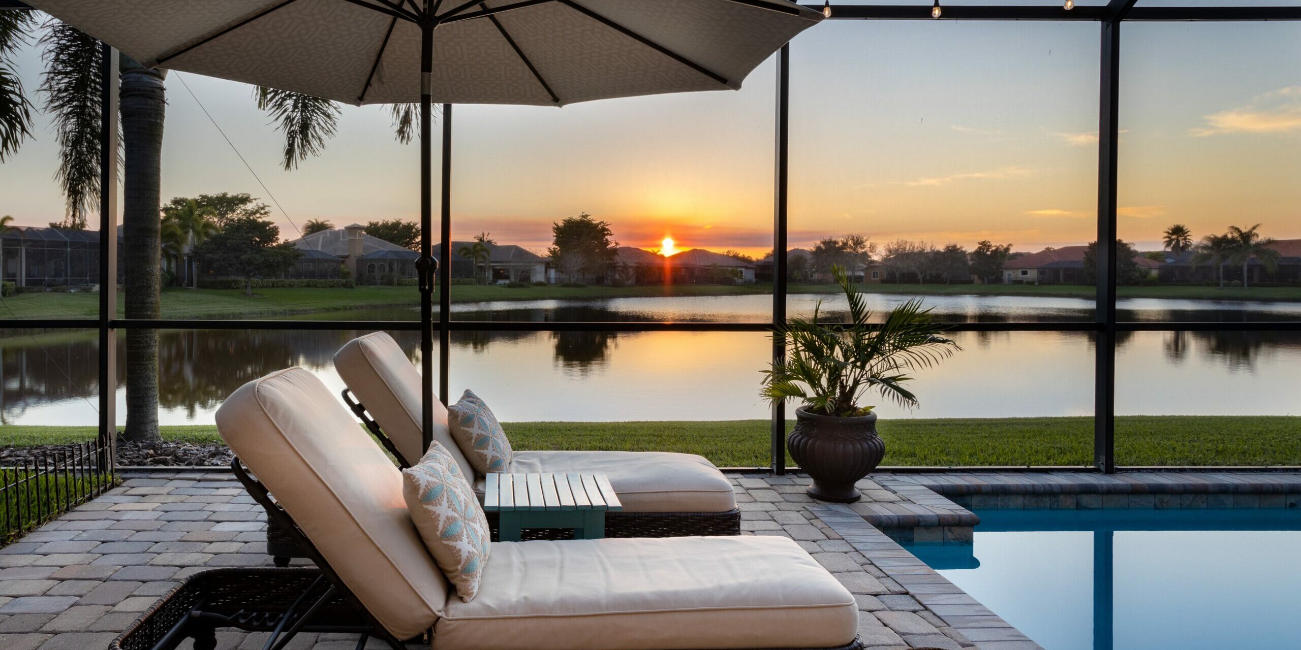 Florida screened swimming pool with lounge chairs overlooking la